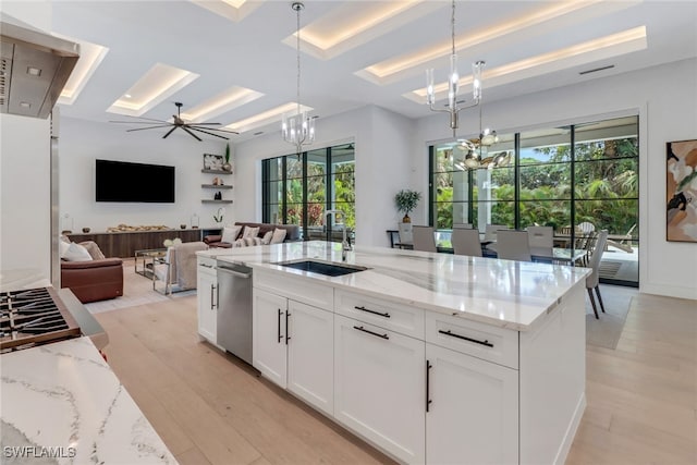 kitchen with light stone counters, sink, a wealth of natural light, and white cabinets