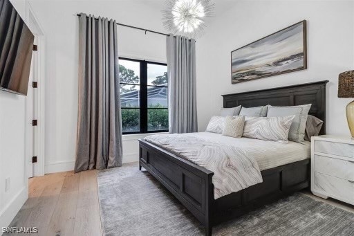 bedroom featuring a chandelier and dark wood-type flooring