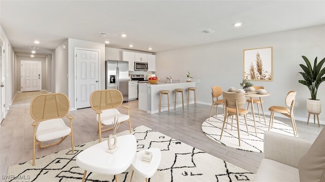 living room featuring light wood-type flooring and sink