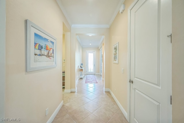 corridor with ornamental molding and light tile patterned flooring