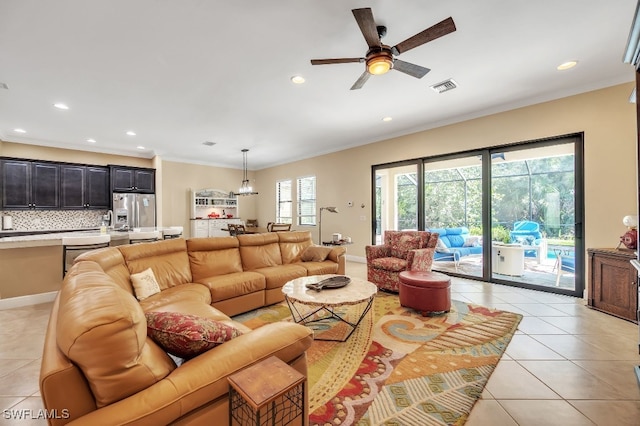 tiled living room featuring ornamental molding, ceiling fan, and plenty of natural light