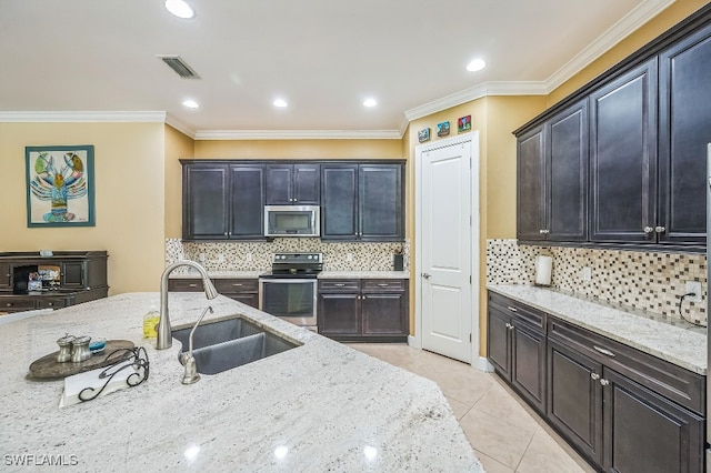 kitchen featuring ornamental molding, sink, light stone countertops, light tile patterned flooring, and appliances with stainless steel finishes