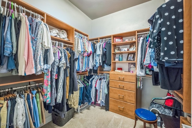 walk in closet featuring light colored carpet