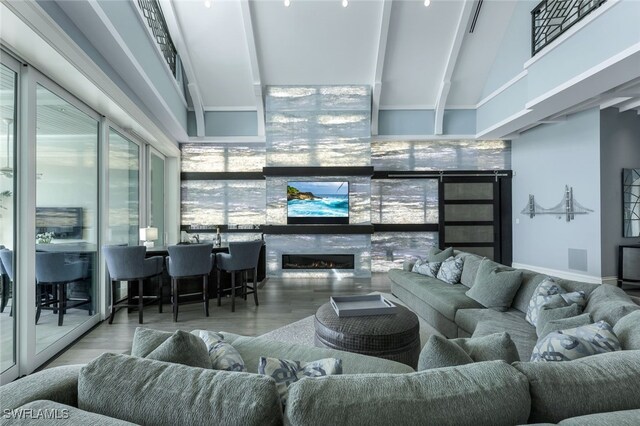 living room with expansive windows, a towering ceiling, beam ceiling, and hardwood / wood-style floors