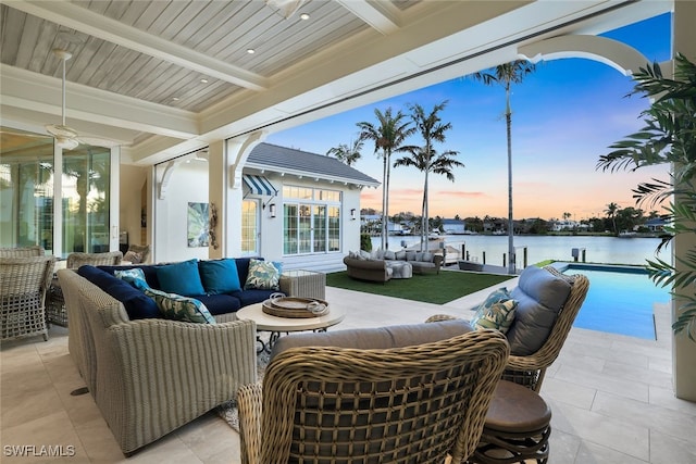 view of patio / terrace with a water view, an outdoor living space, and an outdoor pool