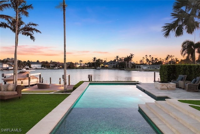 pool at dusk featuring a fire pit, a patio area, a boat dock, and a water view