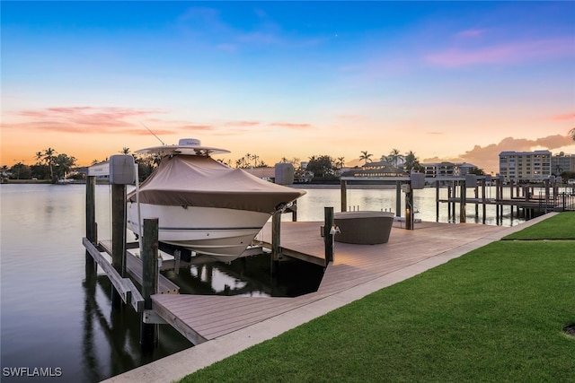 dock area featuring a water view, a yard, and boat lift