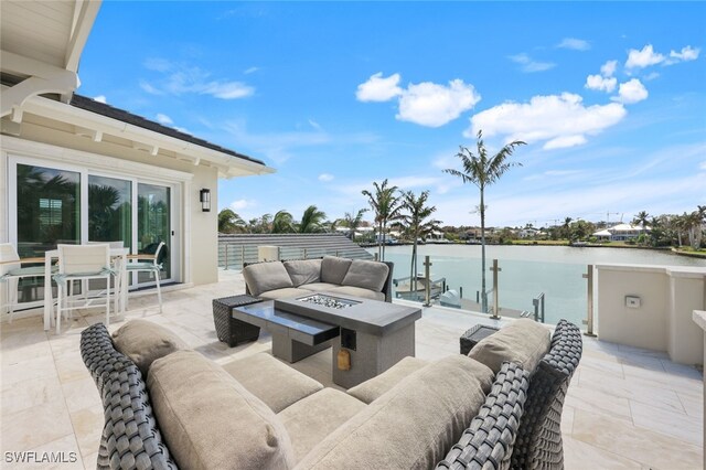 view of patio / terrace featuring an outdoor living space with a fire pit and a water view