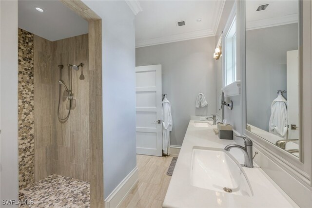 bathroom with crown molding, tiled shower, and vanity