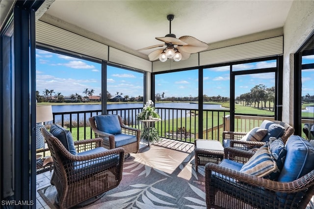 sunroom featuring a water view and ceiling fan