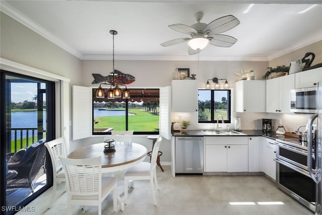 kitchen featuring hanging light fixtures, stainless steel appliances, backsplash, white cabinets, and a water view