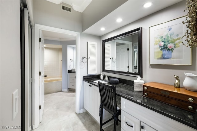 bathroom featuring vanity, crown molding, a washtub, and tile patterned flooring