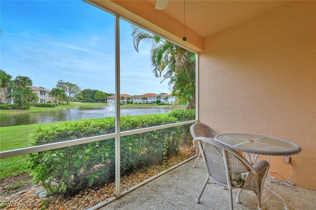 sunroom / solarium featuring a water view