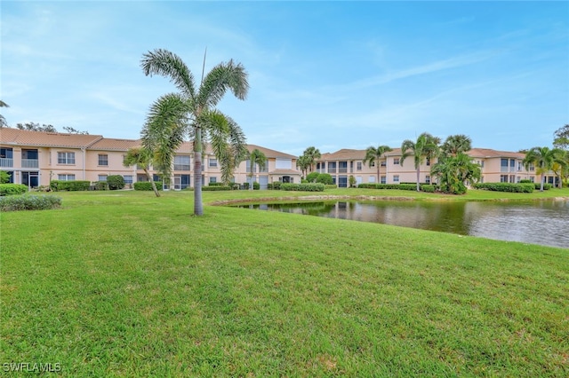 surrounding community with a water view and a yard