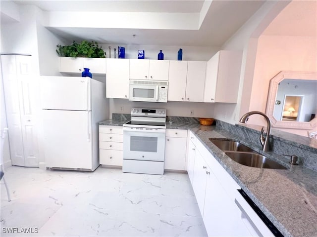 kitchen with white cabinets, white appliances, stone counters, and sink