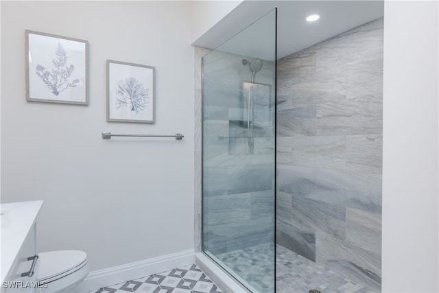 bathroom featuring vanity, toilet, and a shower with shower door