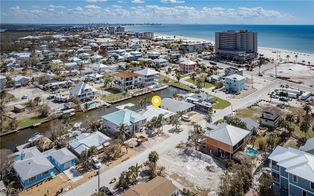 birds eye view of property with a water view and a beach view