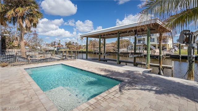 view of swimming pool with a patio, a dock, and a water view