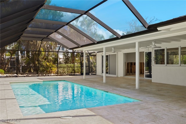 view of pool featuring ceiling fan, a patio area, and glass enclosure