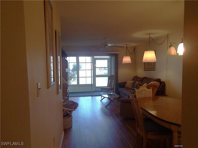living area with a ceiling fan and wood finished floors