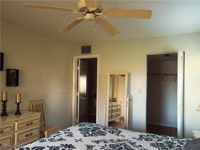 bedroom featuring a closet, a spacious closet, dark wood-type flooring, and ceiling fan