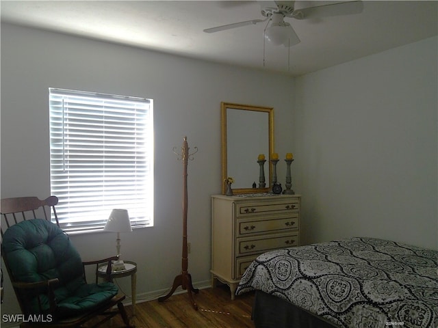 bedroom featuring ceiling fan, multiple windows, and dark hardwood / wood-style flooring