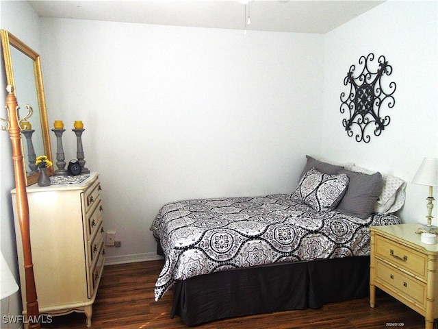 bedroom with dark hardwood / wood-style floors