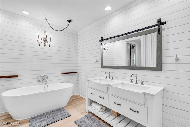 bathroom with a bathtub, wood walls, wood-type flooring, and vanity