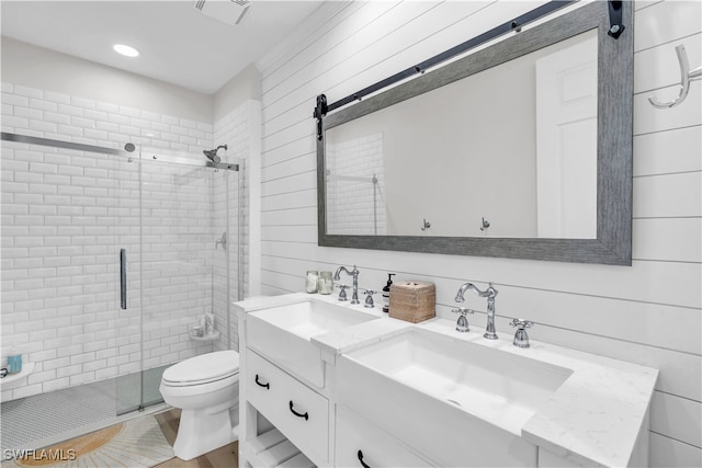 bathroom featuring walk in shower, vanity, wooden walls, and toilet