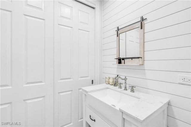 bathroom with vanity and wood walls