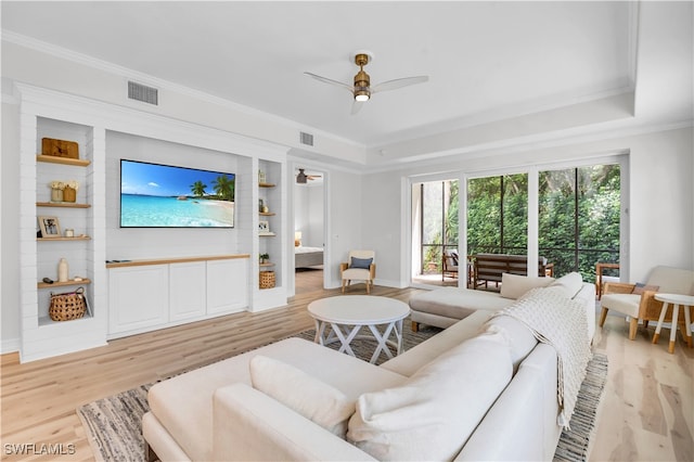 living room with crown molding, light hardwood / wood-style floors, and ceiling fan