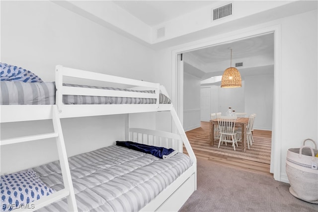 bedroom with hardwood / wood-style flooring and a tray ceiling