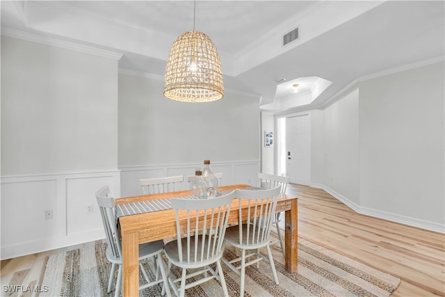 dining space featuring light hardwood / wood-style floors, a notable chandelier, and ornamental molding