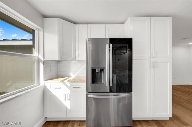 kitchen with white cabinetry, stainless steel fridge, and light wood-type flooring