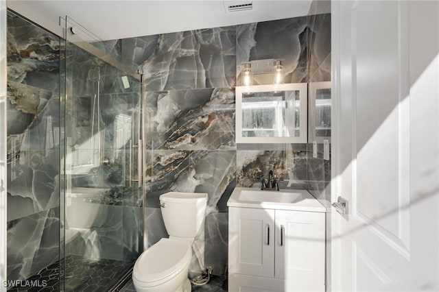 bathroom featuring tile walls, vanity, toilet, and walk in shower