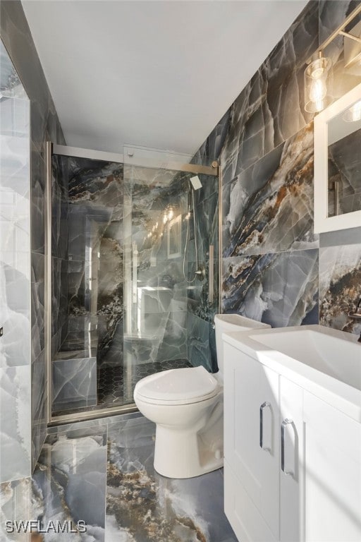 bathroom featuring vanity, toilet, and tile walls