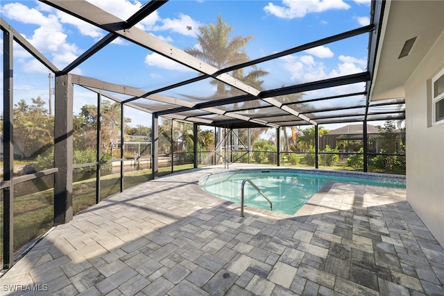 view of swimming pool featuring a patio area and a lanai