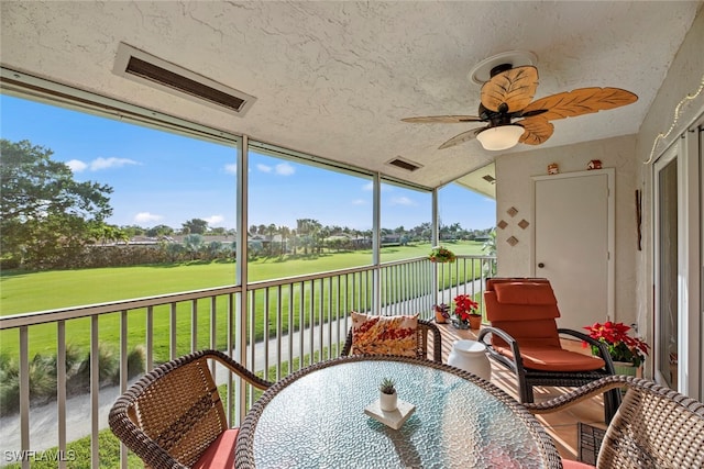 sunroom / solarium featuring ceiling fan