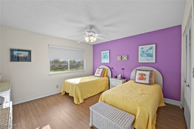 bedroom featuring a closet, a textured ceiling, light wood-type flooring, and ceiling fan