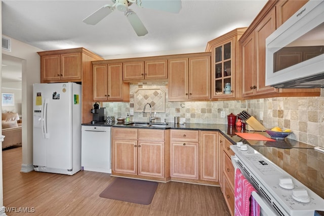 kitchen featuring white appliances, light hardwood / wood-style floors, sink, and backsplash