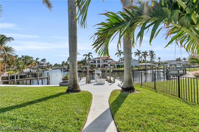 view of dock with a water view and a yard