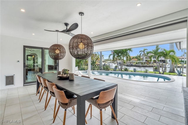 dining room with a water view and light tile patterned floors