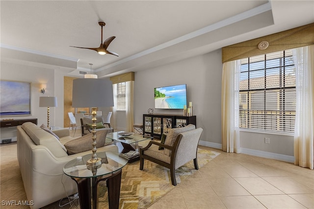 living room with crown molding, light tile patterned flooring, a raised ceiling, and ceiling fan