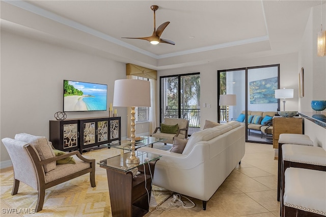 living room featuring ceiling fan, light tile patterned flooring, and a raised ceiling