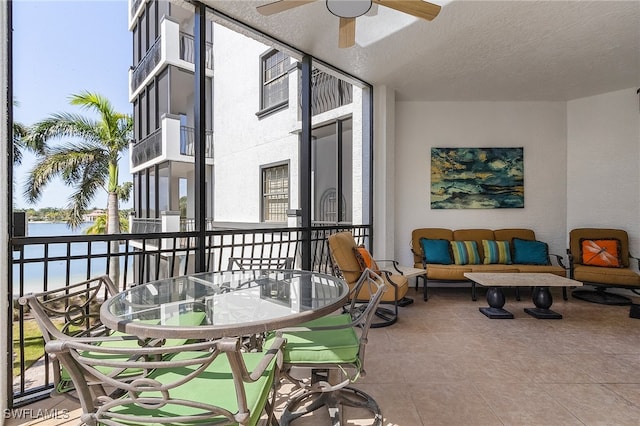 balcony featuring outdoor lounge area, a water view, and ceiling fan