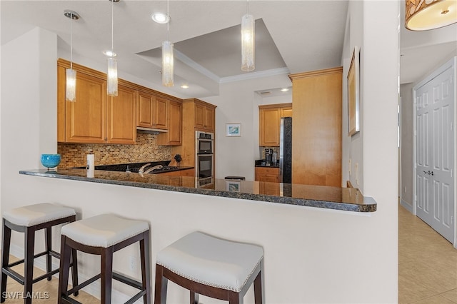 kitchen featuring kitchen peninsula, decorative backsplash, dark stone counters, pendant lighting, and stainless steel appliances