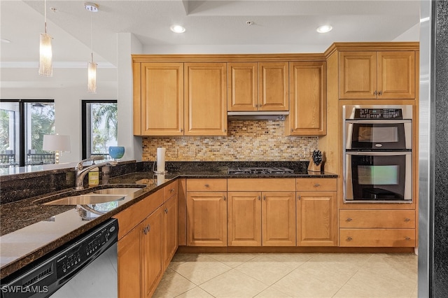 kitchen with sink, hanging light fixtures, stainless steel appliances, dark stone countertops, and ornamental molding