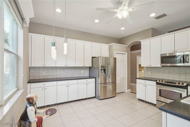 kitchen with white cabinets, decorative light fixtures, decorative backsplash, and appliances with stainless steel finishes