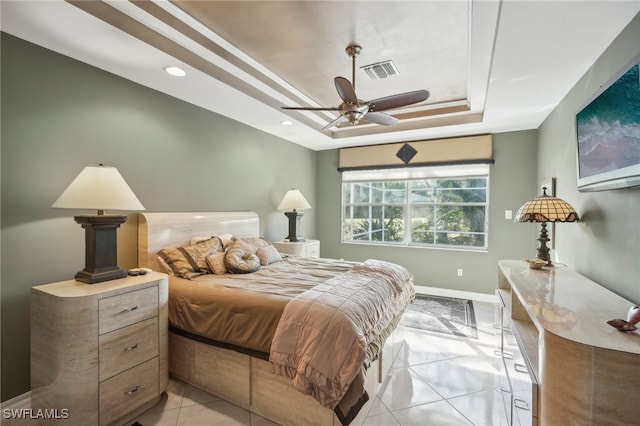 tiled bedroom with a tray ceiling and ceiling fan