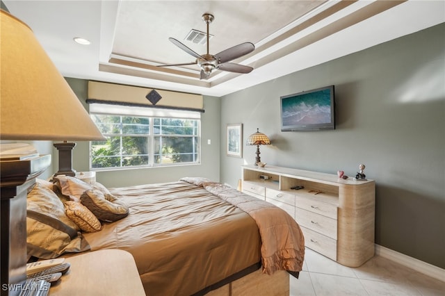 tiled bedroom featuring ceiling fan and a raised ceiling